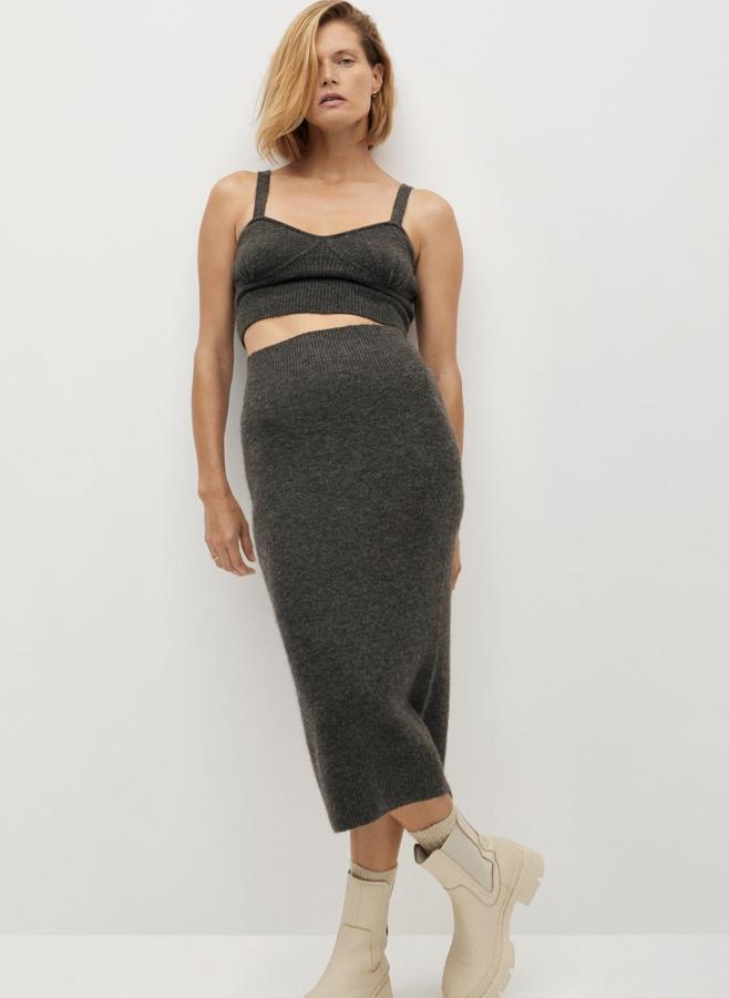 En color gris oscuro, este conjunto de punto y lana de Mango está formado por una falda (25,99 euros) entallada de corte midi y un crop top (19,99 euros) de tirantes con detalles elásticos.