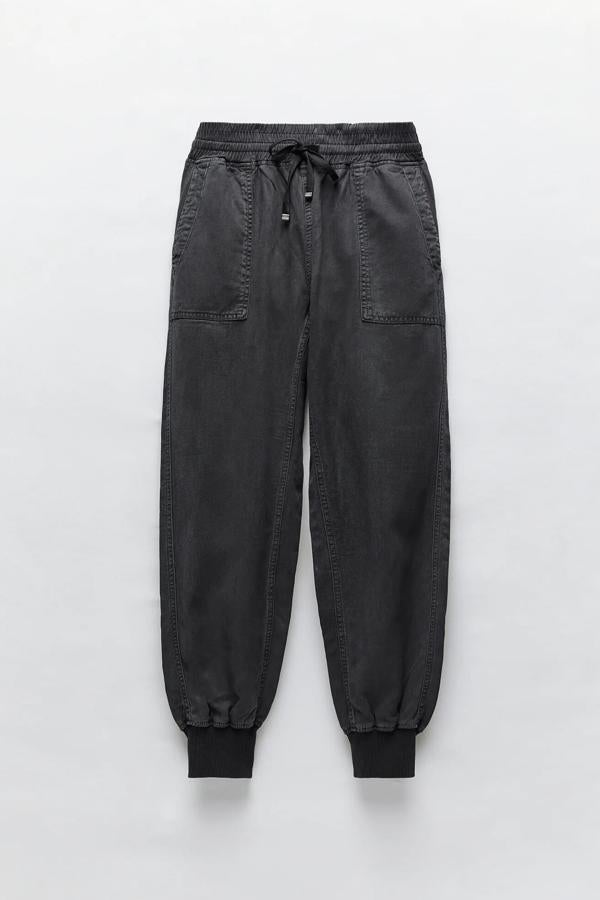 Disponible en varios colores, este pantalón jogger fluido de tiro alto con cintura elástica ajustable con cordones cuenta con bajo acabado en puño elástico. En gris oscuro, es de Zara y tiene un precio de 25,95 euros.