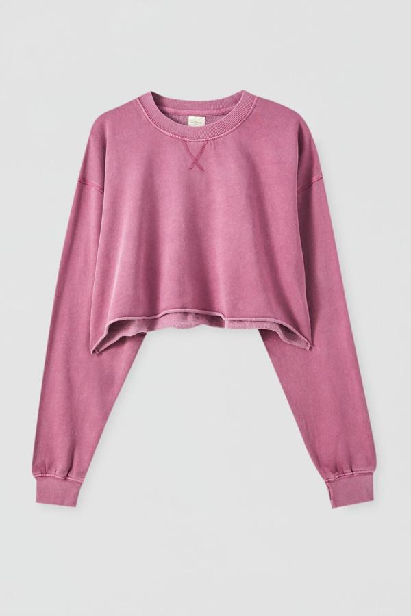 Esta sudadera de efecto lavado en color malva está disponible en otros tonos. En tejido elástico, es de Pull & Bear y tiene un precio de 15,99 euros.