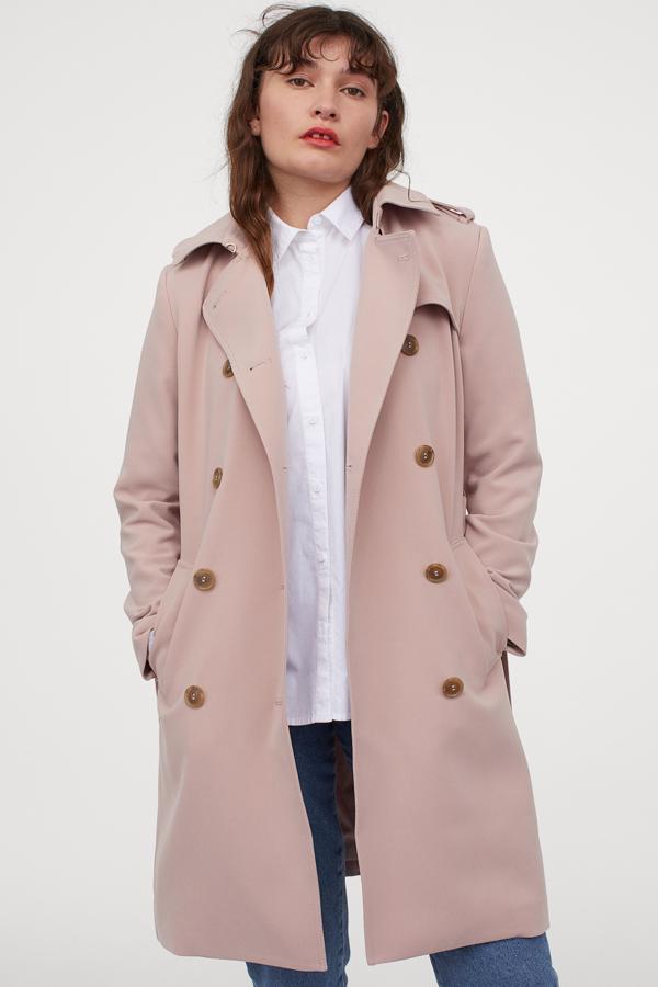 Disponible en beige, camel y negro, esta gabardina en rosa pálido nos ha parecido la opción más inesperada. Disponible entre la talla 32 y la 50, su largo hasta las rodillas nos protege de los días de viento y lluvia y el cinturón nos permite ajustarla para marcar cintura.