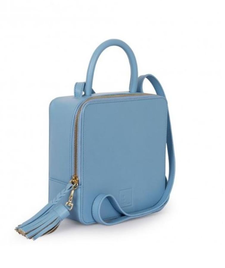Bolso cuadrado con borla y asa fina en azul, de Leandra Bags (260 euros).