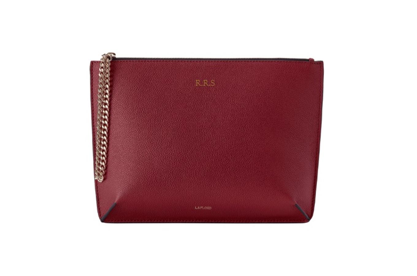 Bolso personalizable de mano de piel en color granate con asa de cadena, de Lafloïd (470 euros).
