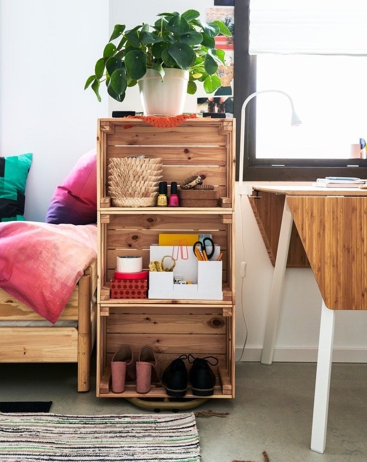 Seguro que duramente mucho tiempo has ido acumulando en casa cajas y más cajas de madera (donde viene la fruta y la verdura, por ejemplo) con el fin de “hacer algo” con ellas, pero nunca se te ha ocurrido el qué. Pues bien, solo tienes que lijarlas y pintarlas de tu color favorito (o dejarlas con un acabado natural, como prefiera) y convertirlas, como nos propone IKEA en la foto, en una estantería o una mesilla de noche. Bastará que les busques un lugar idóneo, las estabilices bien pegando unas con otras, atornillándola o anclándolas en la pared y ordenes dentro lo que necesites. Además, puedes usar la parte de arriba para colocar adornos como macetas con plantas, un florero, luces, velas o marcos de fotos.