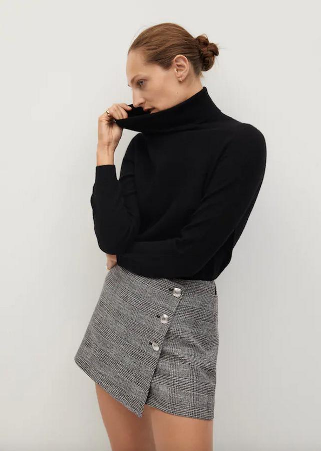 Estampado Príncipe de Gales sobre fondo gris para esta falda pantalón de Mango con diseño cruzado corto y asimétrico, con detalle de botones plateados en un lateral y cierre de cremallera. Cuesta 25,99 euros y está disponible en las tallas 34, 38, 40 y 42.