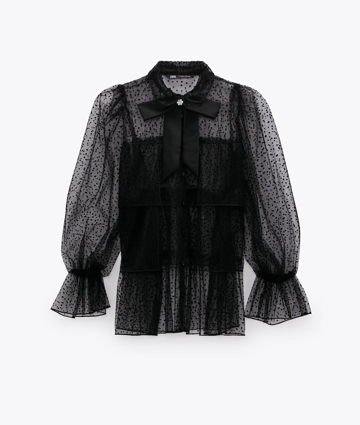 Blusa negra semitransparente de tejido plumeti y lazada de la colección de Zara. (25,95 euros).
