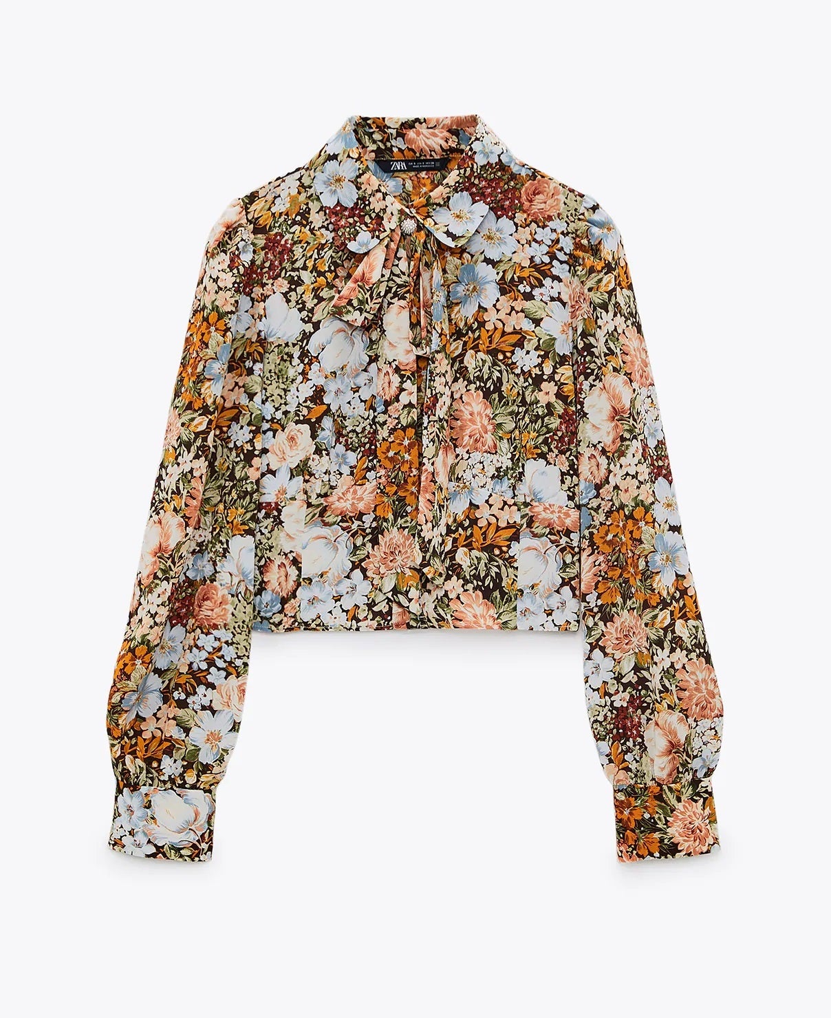 Blusa con estampado de flores, cuello con lazada y botón joya. El estilo romántico más actualizado para el otoño. (25,95 euros).