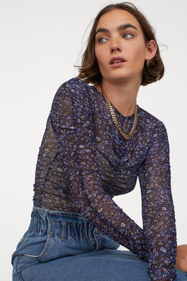Este body en tonos azules con estampado floral de H&M viene con encaje calado con strech, con cuello redondo, corte alto detrás y elástico vertical fino en delantero, espalda y laterales para un efecto drapeado. Tiene un precio de 19,99 euros y está disponible entre las tallas XS y XL.