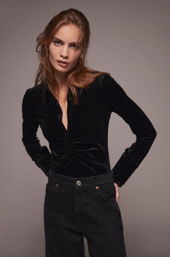 Con cuello de solapa y mangas largas, este body de terciopelo de Zara viene con detalle de frunce en delantero y cierre con botones tipo polo en el frontal. Cuesta 22,95 euros y está disponible entre las tallas XS y XL.
