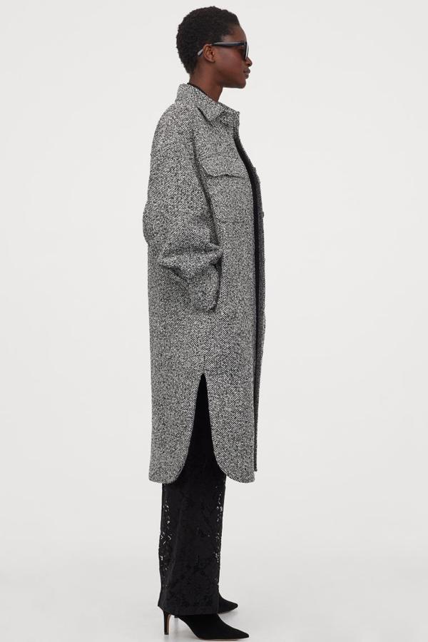 En negro jaspeado, de corte recto, botones delanteros y canesú en la espalda, esta chaqueta camisera viene con bolsillos superiores con solapa, bolsillos ocultos en las costuras laterales y hombros caídos. Tiene mangas amplias con botones en los puños y bajo redondeado asimétrico. Está disponible entre las tallas XS y XXL, podemos comprarla por 49,99 euros.