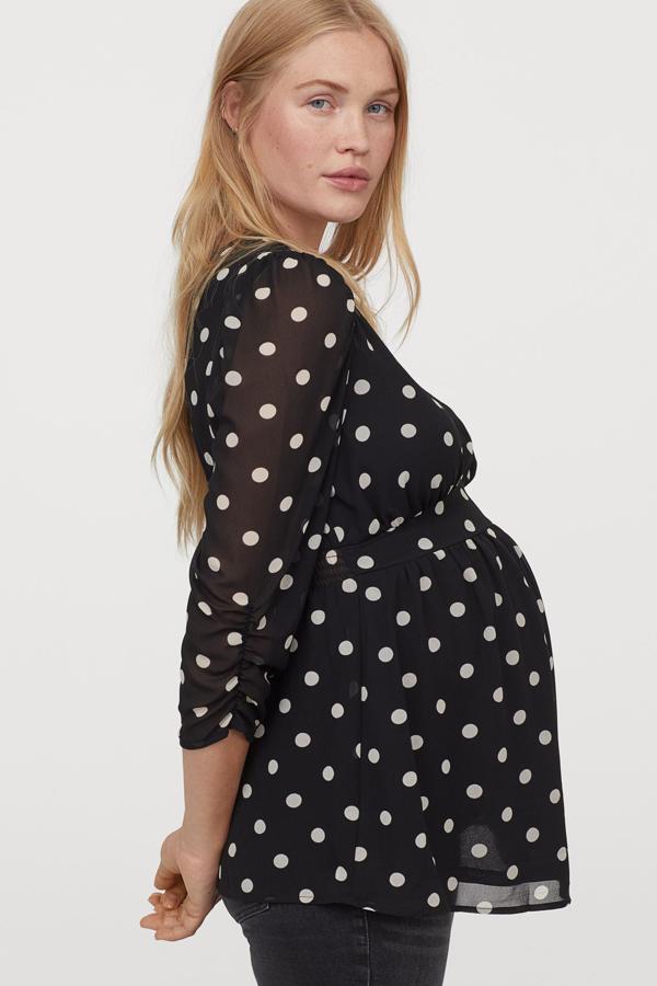 Esta blusa de gasa negra con lunares blancos cuenta con escote de pico y manga tres cuartos abullonada con costura asimétrica bajo el pecho y fruncido en la parte de atrás. Es de H&M y tiene un precio de 24,99 euros.