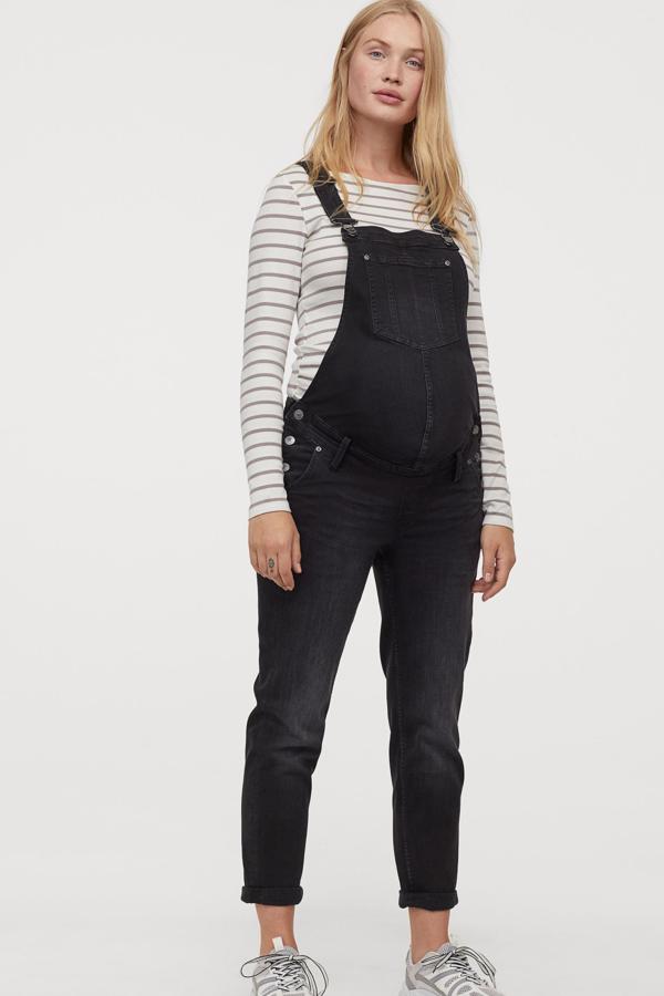 En color negro, este peto denim elástico cuenta con tirantes ajustables y botones en los laterales. Con perneras ajustadas, es de H&M y tiene un precio de 39,99 euros.