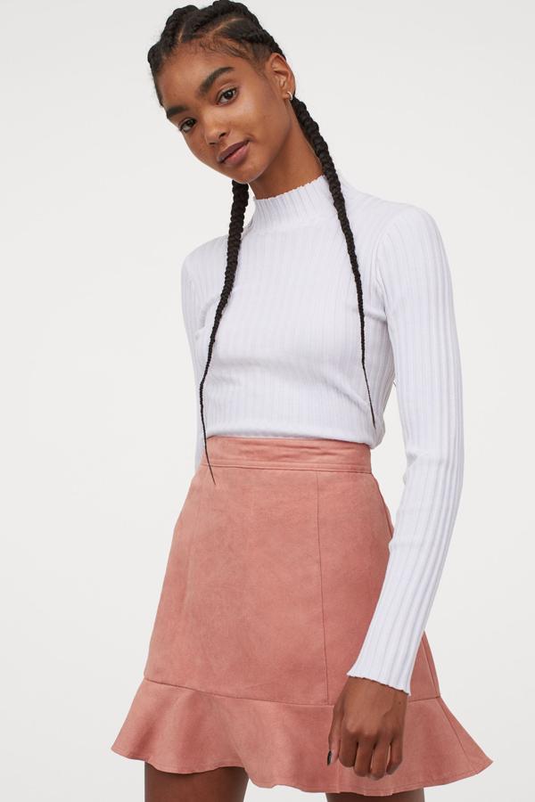 En color rosa, esta minifalda de corte evasé con cremallera en la parte trasera y volante en el bajo tiene un precio de 19,99 euros. Está disponible en otros colores.