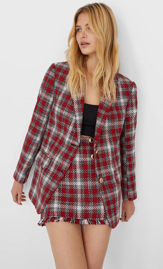 Esta blazer con cuadros en rojo cuenta con bolsillos en la parte delantera y tiene un precio de 39,99 euros. También está disponible la falda pantalón (19,99 euros) a juego con botones en la parte delantera y desflecado en el bajo.