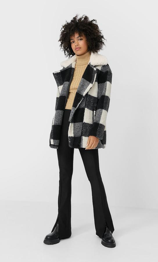 Otra propuesta de borreguito de Stradivarius es este abrigo corto con estampado de cuadros en tonos negros y blancos. Viene con cuello a contraste y cierre frontal de cremallera y cuesta 49,99 euros. Está disponible entre las tallas XS y XL.