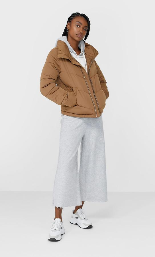 Disponible en rojo, lila, blanco, negro y tostado, esta cazadora acolchada viene con cuello chimenea, cierre de cremallera metálica y bolsillos laterales con forro polar. Cuesta 29,99 euros y está disponible entre las tallas XS y XL.