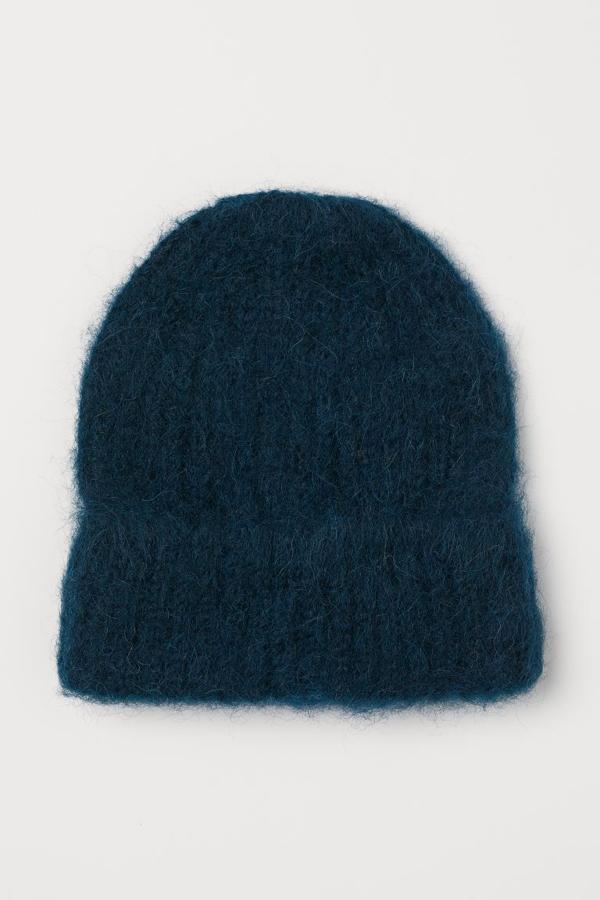 En punto de canalé de mezcla de lana con textura peluda y borde vuelto, este gorro en azul petróleo es de H&M y tiene un precio de 14,99 euros.
