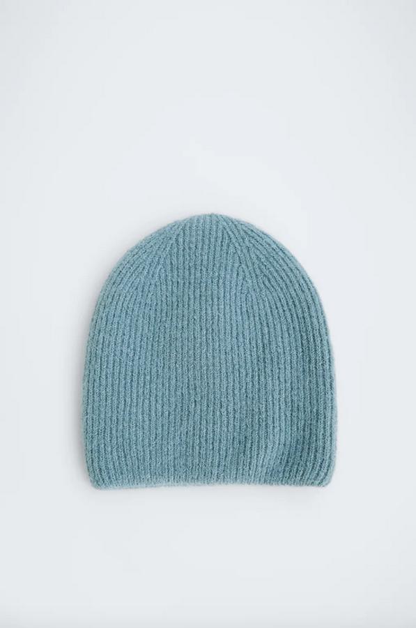 Confeccionado con tejido en mezcla de lana, este gorro de lana en color azul es de Zara y tiene un precio de 12,95 euros. También está disponible en color negro.