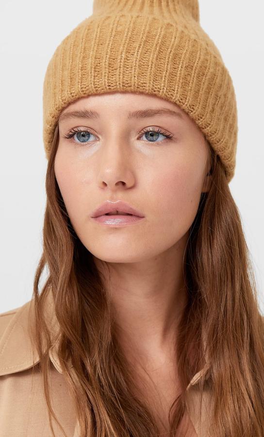 En punto grueso y bajo vuelto, este gorro de lana de Stradivarius está disponible en cinco colores, entre ellos el negro, el blanco o el piedra. Tiene un precio de 7,99 euros.