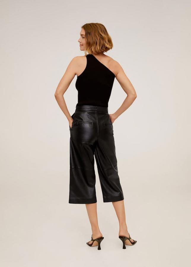 Con un top asimétrico y sandalias de tacón, de Mango (119 €).