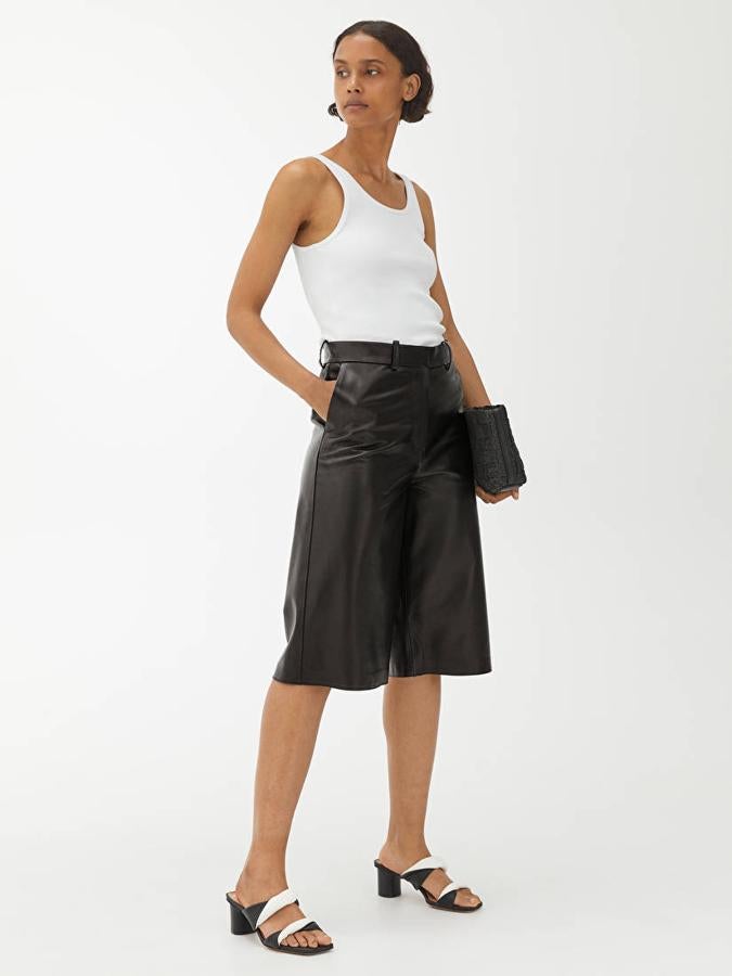 El triunfo de monocromatismo, combinando un top de tirantes blanco y sandalias destalonadas, de Arket (250 €).