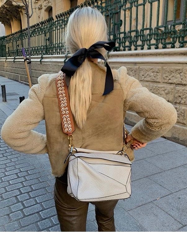 Evita el dolor del cuero cabelludo con esta coleta baja y desenfadada que Mónica Anoz ha combinado con un lazo, uno de los accesorios para el pelo que más rejuvenecen.