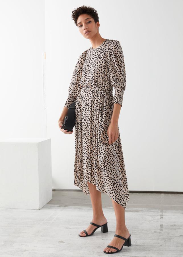 Vestido de largo midi con cintura marcada con un lazo, bajo asimétrico y estampado de motas en blanco y negro sobre fondo beige, de las rebajas de & Other Stories (68 euros).