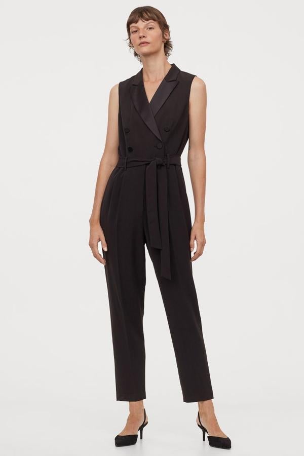 Sin mangas, con solapas de muesca en satén y doble botonadura con botones revestidos de satén, este mono de H&M con costura en la cintura y cinturón a tono extraíble viene con perneras pitillo con raya. Cuesta 49,99 euros y solo se vende en la web de la firma, entre las tallas 32 y 50.