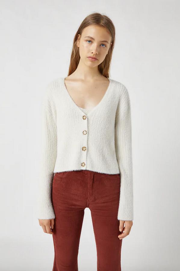 En color crudo, con escote de pico, mangas largas, cuerpo cropped y cierre delantero de botones a contraste, esta chaqueta de pelo corto cuesta 22,99 euros y está disponible entre las tallas XS y L.