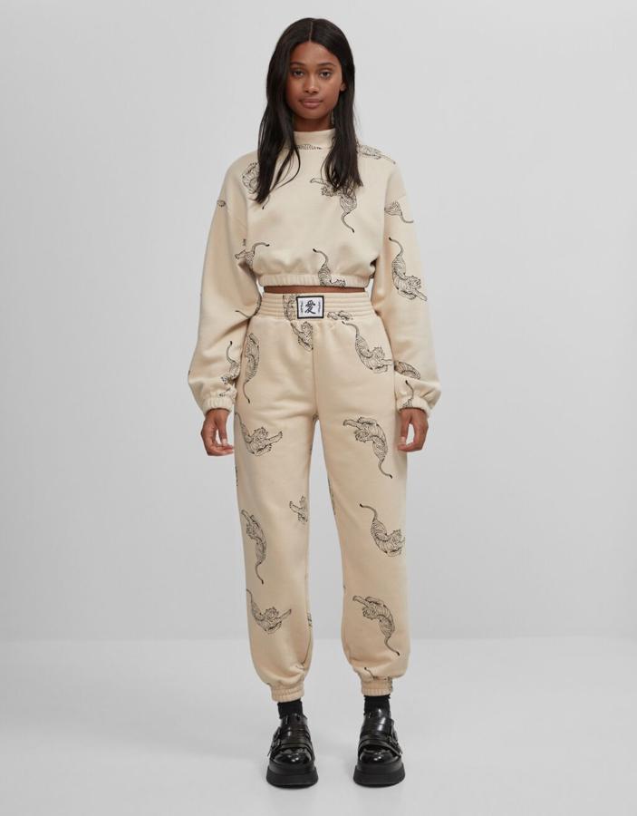 Chándal beige con estampado de tigres, con sudadera cropped (19,99 euros) y pantalón de talle alto (22,99 euros), de Bershka.