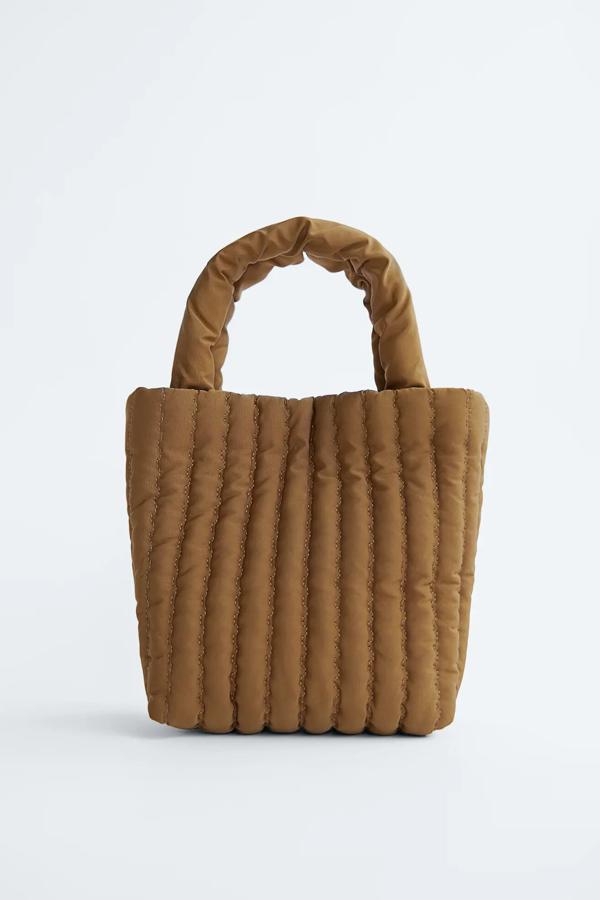 Este bolso pequeño de cuerpo acolchado en color ocre cuenta con asas de mano y cierre mediante imán. Con bolsillo interior con cremallera, tiene un precio de 15,95 euros.