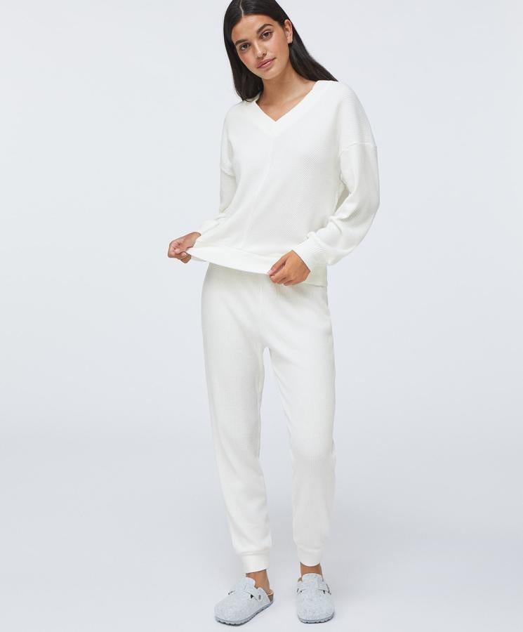 Este conjunto de tejido suave en color crudo, también está disponible en rosa. Cuenta con un pantalón (19,99 euros) largo ajustable en la cintura mediante goma elástica y un jersey (19,99 euros) con cuello de pico a juego.