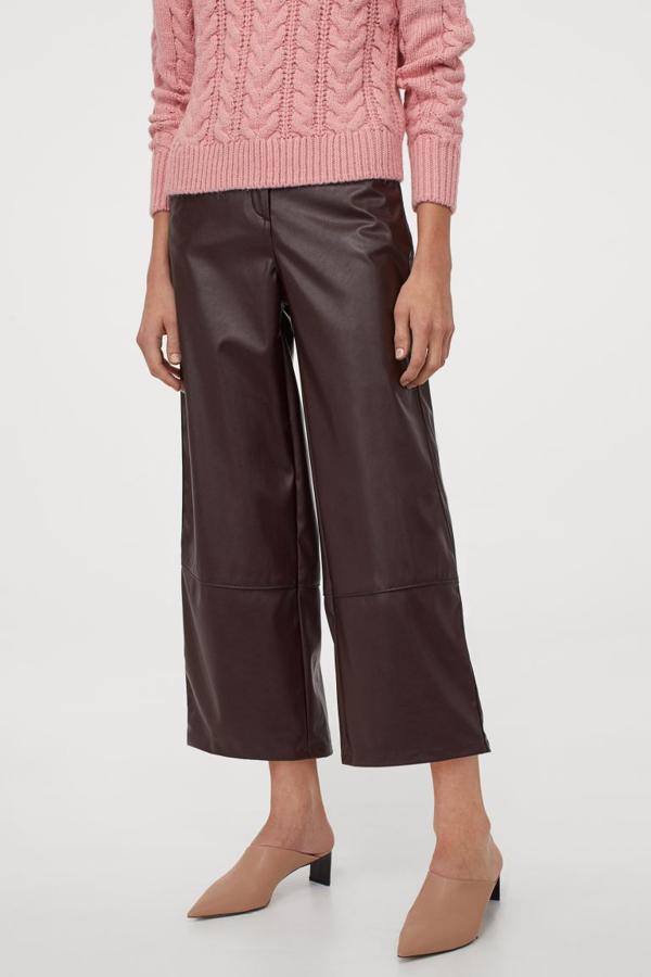 En H&M hemos encontrado esta original propuesta en efecto piel con diseño cuotte, perneras rectas amplias y bolsillos al bies diagonales. Tiene un precio de 29,99 euros y está disponible entre las tallas 32 y 50.