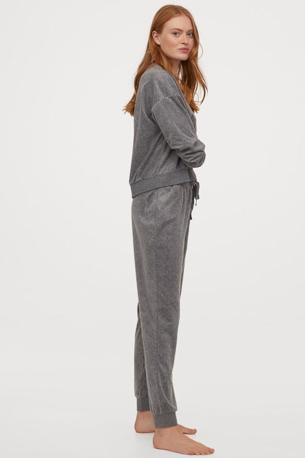De venta exclusiva en la web de H&M, este pijama en polar suave y gris jaspeado viene con sudadera con cuello redondo, hombros cañudos y ribete elástico de canalé en escote, puños y bajo y pantalón con elástico revestido y cordón de ajuste en la cintura. Tiene un precio de 19,99 euros y podemos encontrarlo entre las tallas XS y XL, y en rosa empolvado.