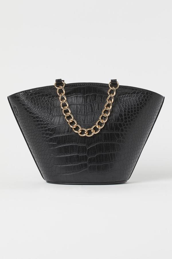 Grande y de inspiración shopper, en este bolso de H&M te cabe todo lo que quieras llevar y no puede ser más elegante a pesar de su tamaño (24,99 euros).