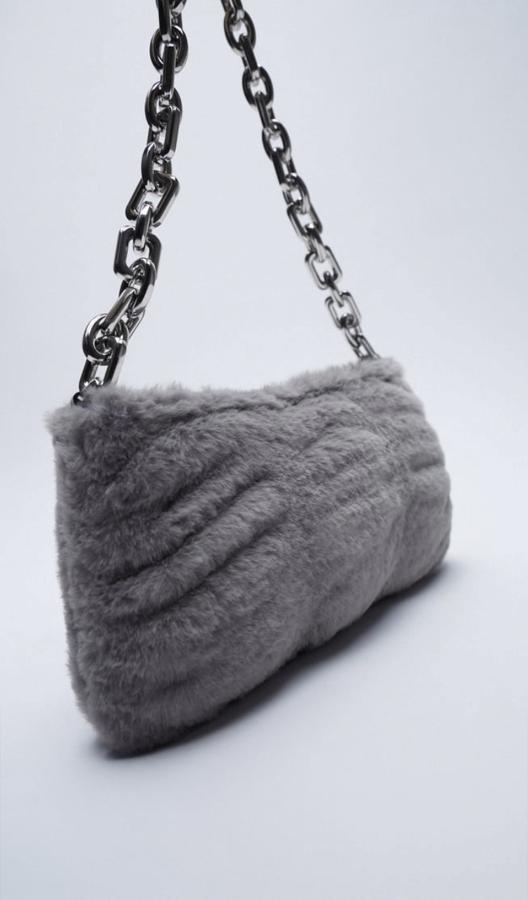 Si buscas algo diferente, ¿por qué no te animas con el peluche? Tendrás el bolso más amoroso. Este es en color gris, de Zara (25,95 euros).