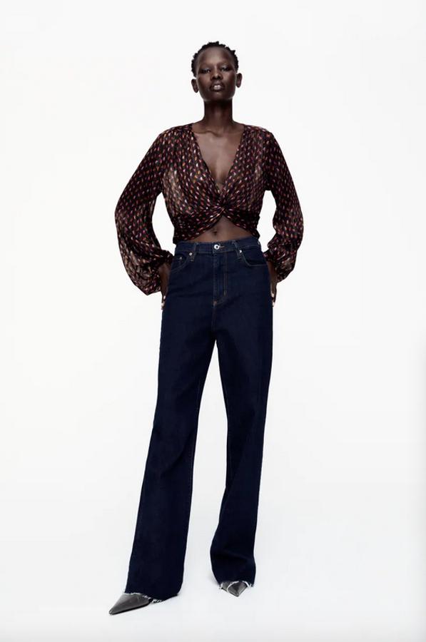Diseño cropped con escote de pico para este top negro de Zara con estampado en tonos naranjas y rosas. Con mangas largas abullonadas acabadas en puño elástico, viene con tejido tipo nido de abeja en la espalda y detalle de nudo en el frontal. Podemos encontrarlo entre las tallas XS y XL por 29,95 euros.