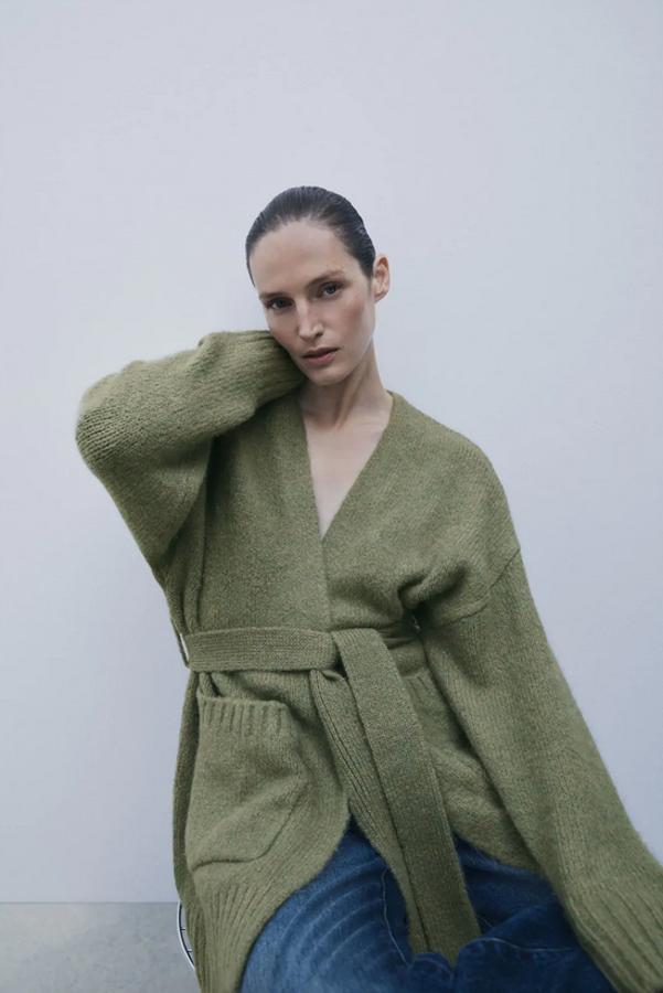 Diseño oversize para este cárdigan de Zara en caqui claro, con bolsillos delanteros de plastrón, con cinturón a tono y acabados en rib. Con un precio 29,95 euros, podemos encontrarlo en las tallas S y M.
