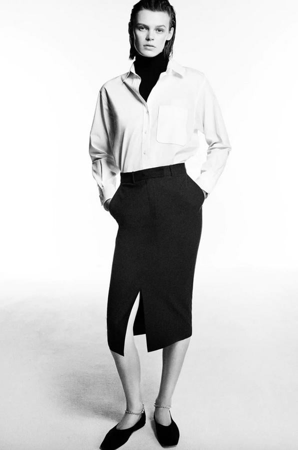 En color negro, con tiro alto y bolsillos laterales, esta falda de tubo de Zara en color negro tienen abertura en el bajo en la parte frontal y está confeccionada con al menos un 50% de poliéster reciclado. Cuesta 19,95 euros y podemos encontrarla entre las tallas XS y XXL.