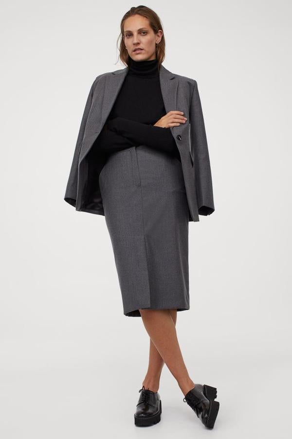 En tejido de lana, con talle alto y bolsillos al bies, esta falda midi ajustada de H&M con abertura delantera en color gris oscuro tiene un precio de 79,99 euros y está disponible entre las tallas 34 y 46, aunque las tres últimas se están agotando.