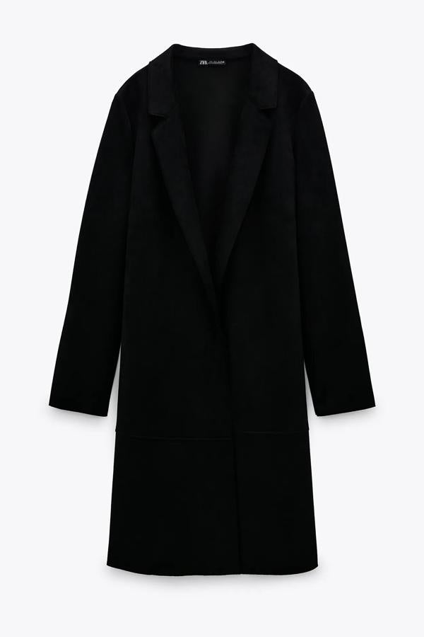 Este abrigo de efecto ante en color negro cuenta con cuello solapa y bolsillos laterales ocultos en la costura. Es de Zara y tiene un precio de 29,95 euros.