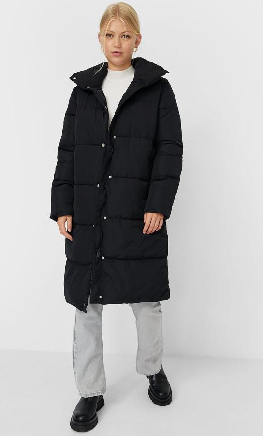 Este abrigo largo de cuello alto y cierre mediante corchetes cuenta con bolsillos frontales y tiene un precio de 39,99 euros. Es de Stradivarius.