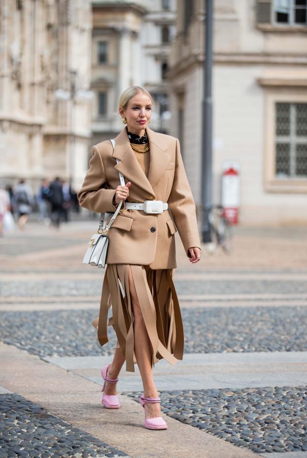 El contraste del volumen de la americana y el movimiento de la falda de flecos se fusiona con accesorios en tonos rosas en un llamativo look muy femenino.