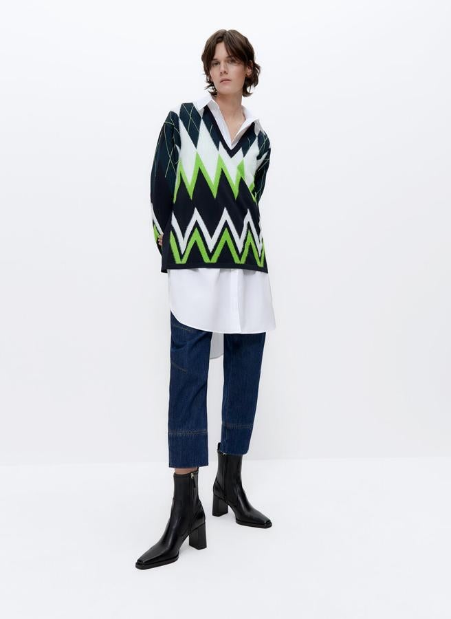 Uno de los diseños más originales y atemporales es el de este jersey de Uterqüe con cuelo de pico jacquard con rombos, mangas largas, acabados en rib y diseño oversize en negro, blanco y verde flúor. Cuesta 99 euros y está disponible en las tallas S y M.