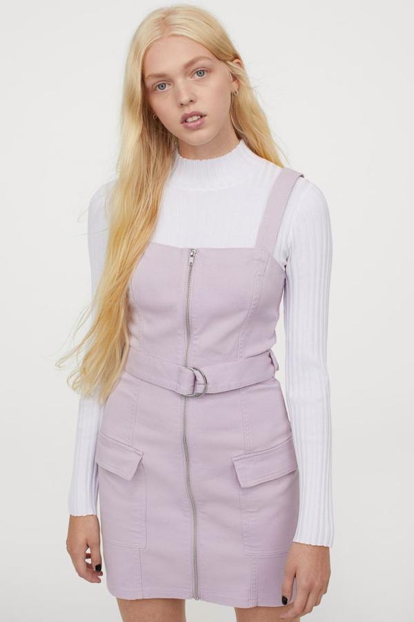 Confeccionado en sarga, con tirantes amplios, cierre de cremallera y bolsillos al bies de parche con solapa, este pichi lila de H&M con diseño ligeramente ajustado viene con cinturón extraíble a tono. Tiene un precio de 24,99 euros y en la web está agotado en todas las tallas.