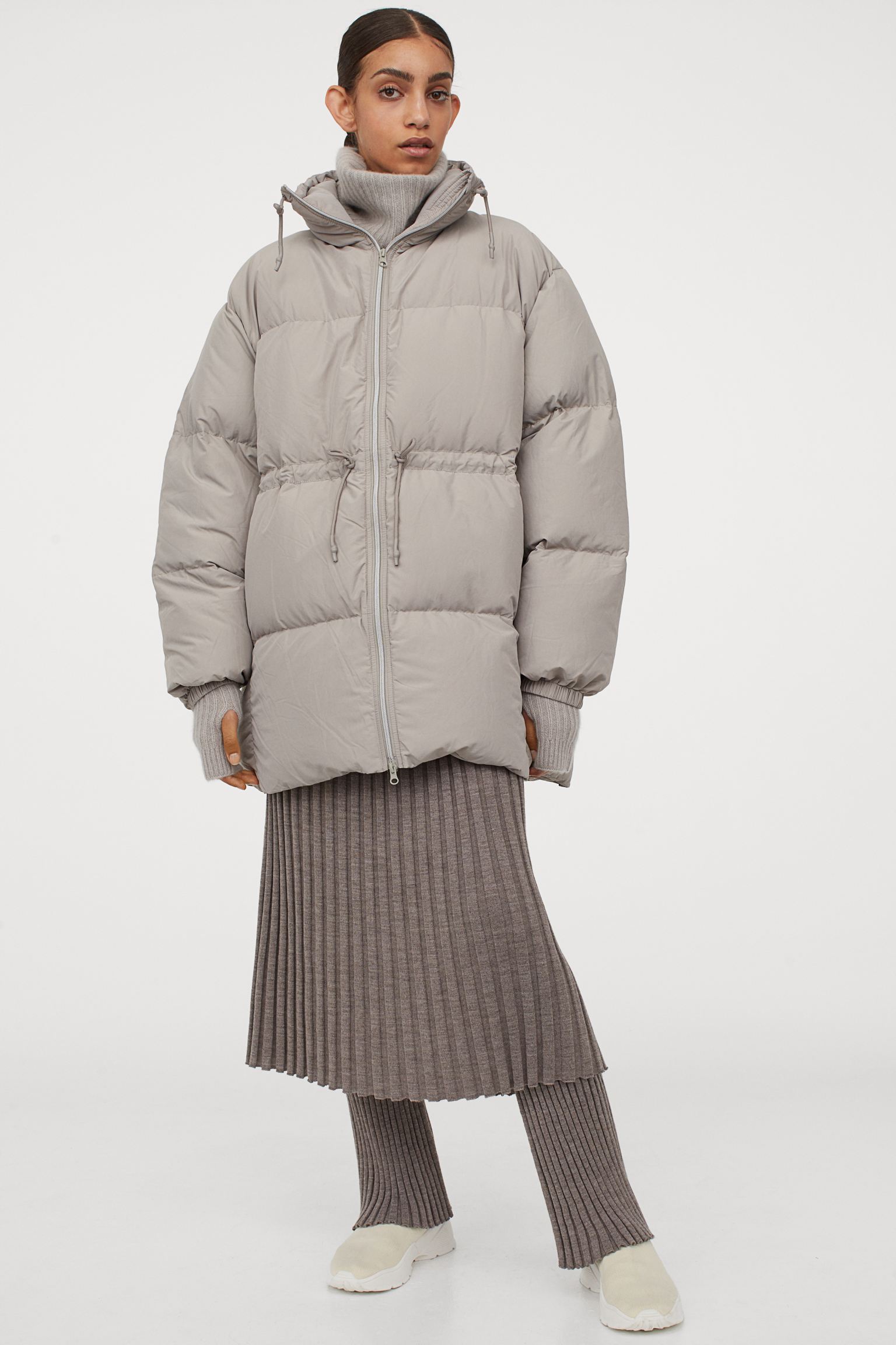 De todas las opciones que ofrece la nueva colección de H&M nos quedamos con el abrigo más efectivo: este plumífero beige grisáceo con cuello chimenea, cierre de cremallera, puños elásticos y cordón ajustable en la cintura para lucir tipazo. (129 euros).