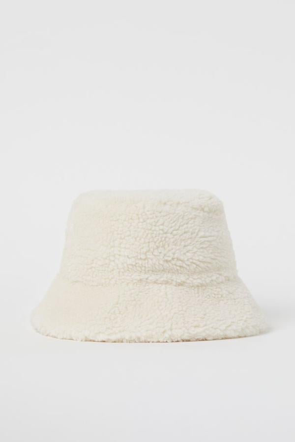Este sombrero bucket de borreguito suave en color blanco de H&M viene con forro en tejido de algodón y tiene un precio de 14,99 euros.