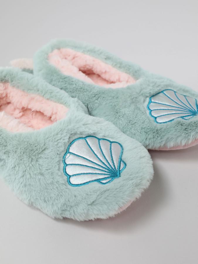 Efecto pelo en turquesa para estas zapatillas con bordado de conchas en el empeine de Lefties. Con el interior rosa en efecto pelo rizo, cuestan 7,99 euros y están disponibles en las tallas M y L.