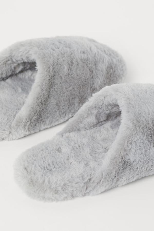 De venta exclusiva en la web de H&M y disponibles en gris o en negro, estas zapatillas de casa en tejido suave con forro y plantillas en pelo sintético. Tienen un precio de 14,99 euros y están disponibles entre los números 36 y 41.