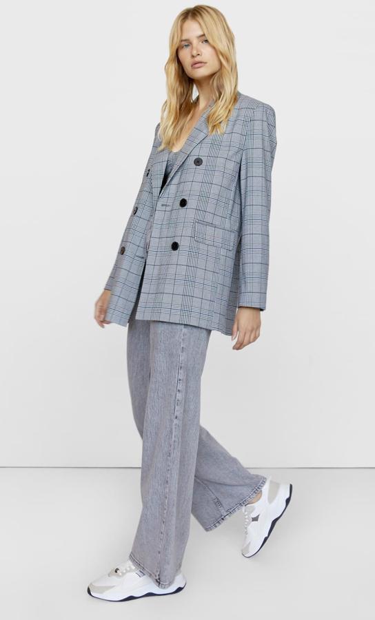 Esta americana oversize con estampado de cuadros en color gris y cierre frontal cruzado con botones tiene un precio de 35,99 euros.