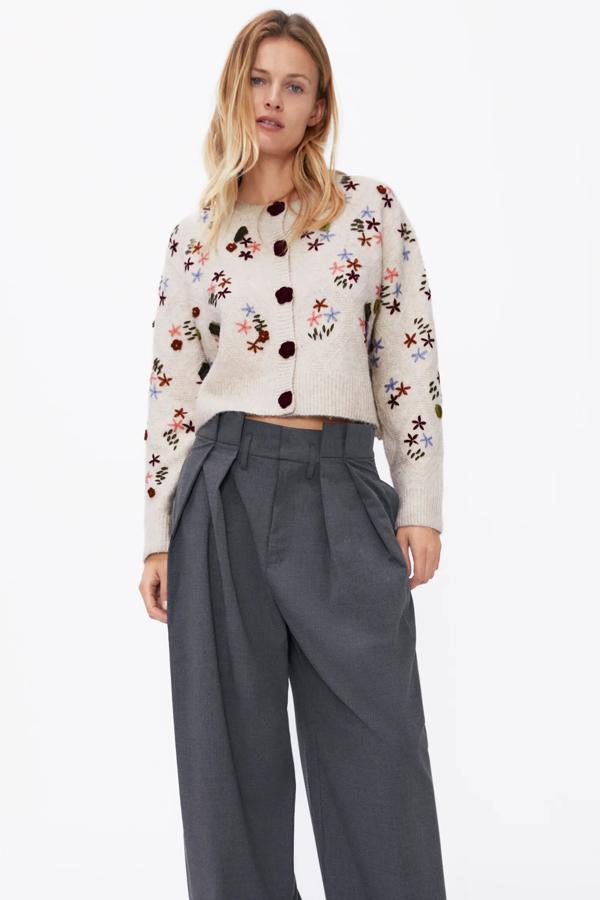 En color beige con detalle de flores en crochet, esta chaqueta de punto con cuello redondo y cierre frontal con botones en forma de flor tiene un precio de 39,95 euros. Es de Zara.